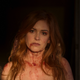 A naked Maya, covered in blood and her red hair streaming down her shoulders, stands in a daze.